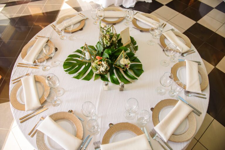 A table set with white and cream linens. Elevate your table linens with Stamford Uniform and Linen.