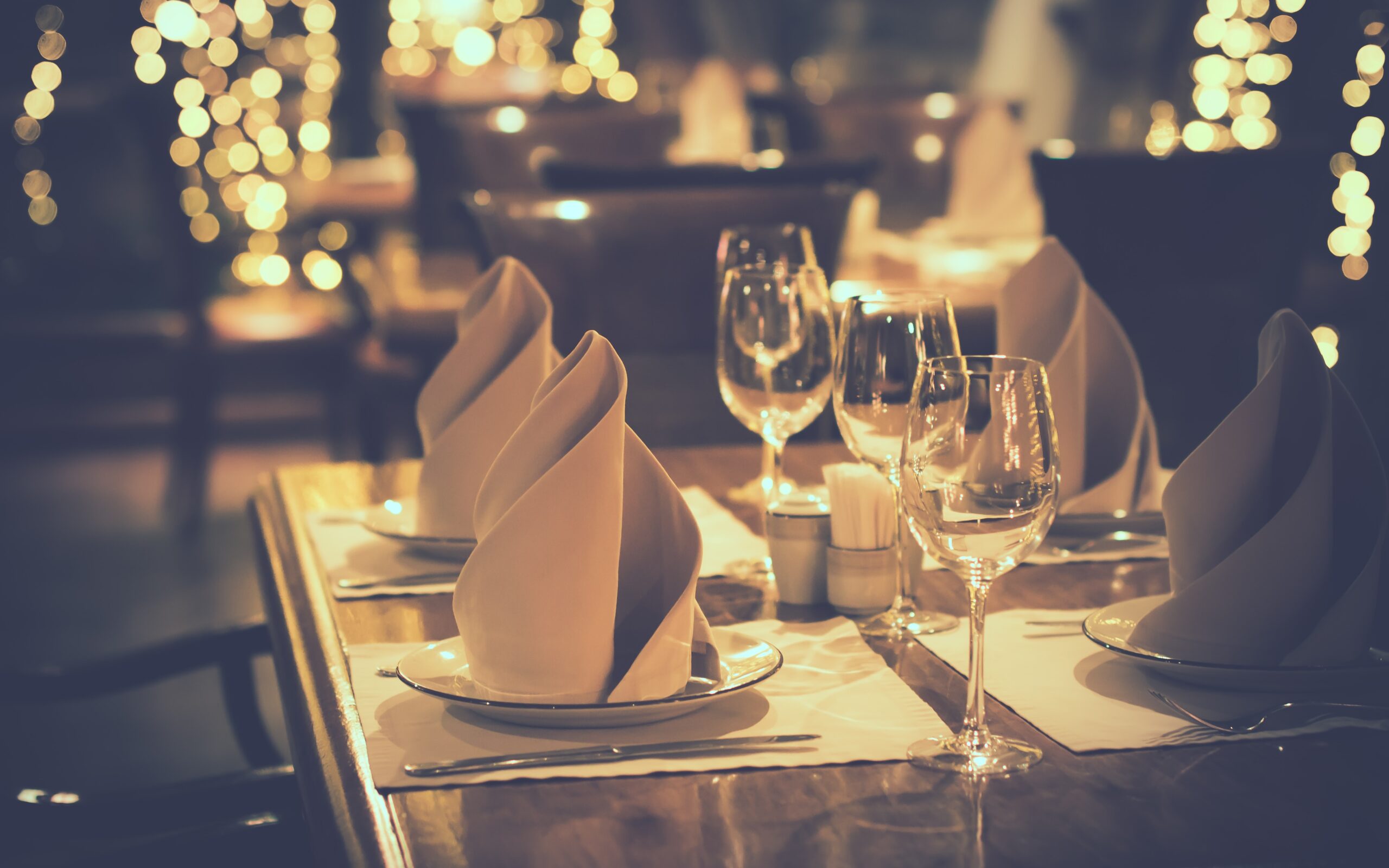 A table set with white and cream linens. Elevate your table linens with Stamford Uniform and Linen.