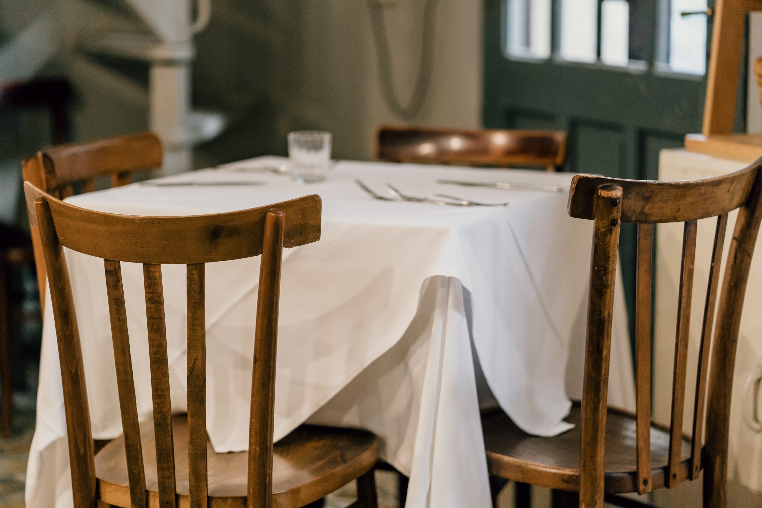 A table set with white linens. Elevate your table linens with Stamford Uniform and Linen.